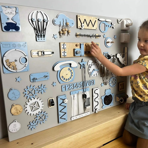 Child interacting with a wall-mounted wooden activity board with various educational elements.