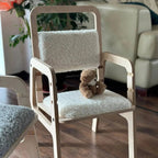 Children's chair with a teddy bear on a wooden floor in a room setting.