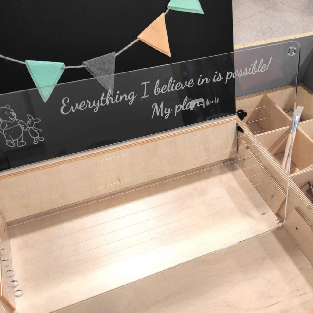Montessori-inspired wooden multisensory art desk with storage, quote, and felt garland