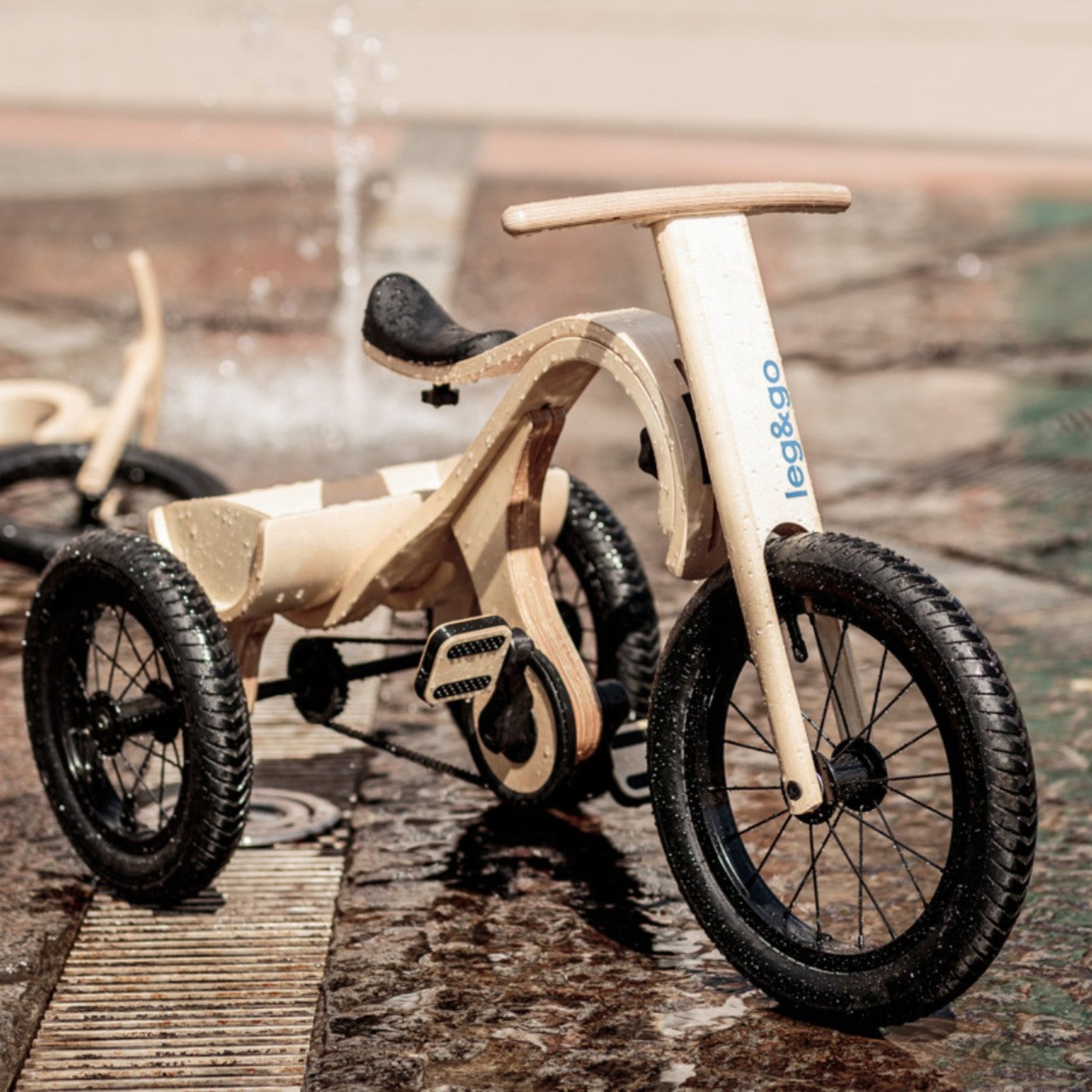 Wooden 3-in-1 tricycle add-on for balance bike with black wheels, wet pavement setting